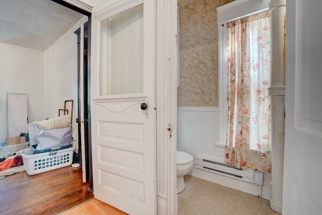 bathroom featuring baseboard heating, hardwood / wood-style floors, and toilet