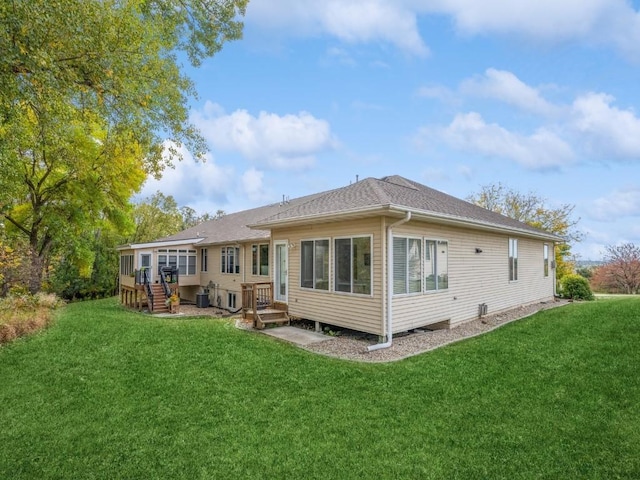 back of house with central AC unit and a yard