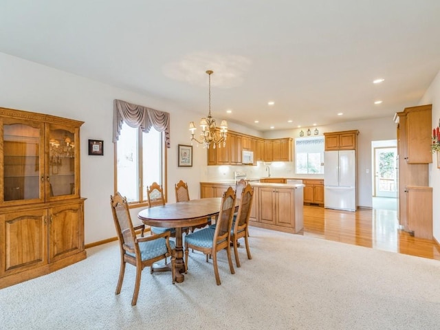 dining room featuring baseboards, recessed lighting, an inviting chandelier, and light colored carpet