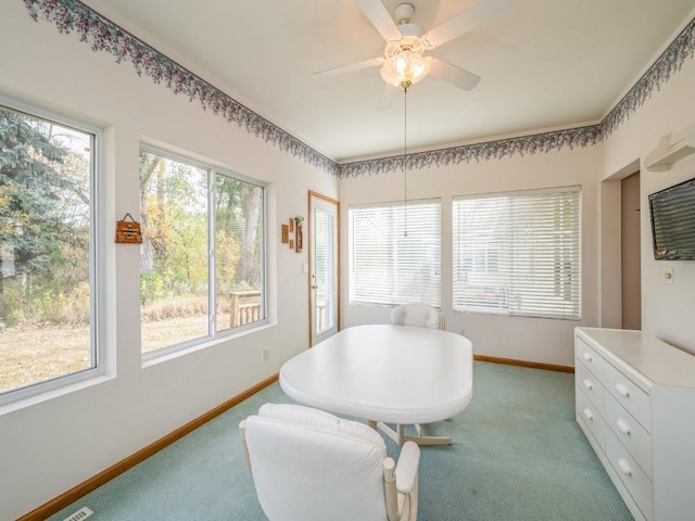 dining area with ceiling fan, baseboards, and light colored carpet