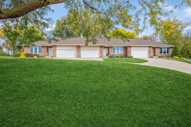 single story home featuring a front yard, concrete driveway, brick siding, and an attached garage