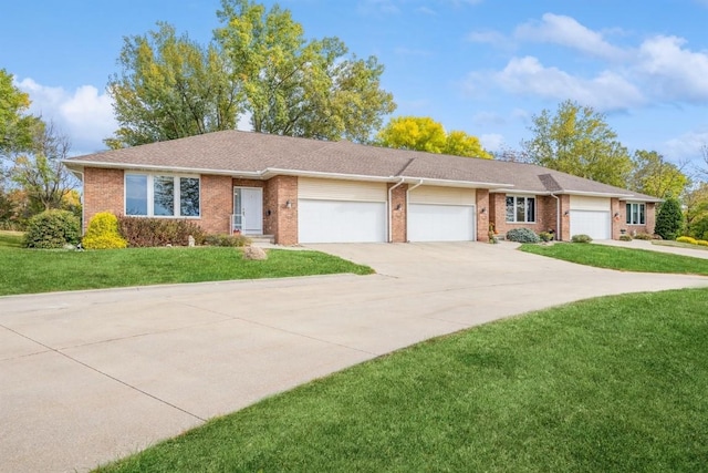 single story home featuring a front yard, concrete driveway, brick siding, and an attached garage