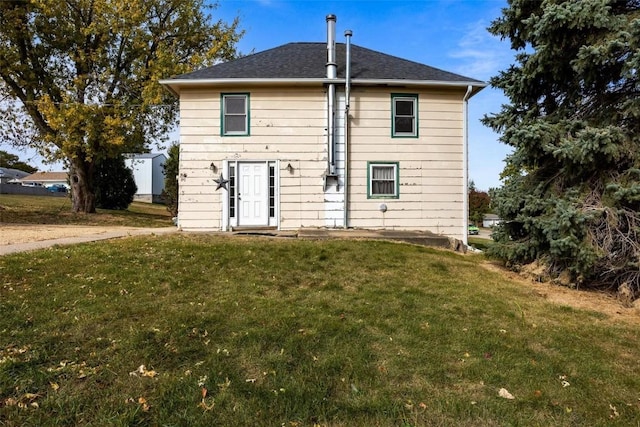 rear view of house featuring a yard