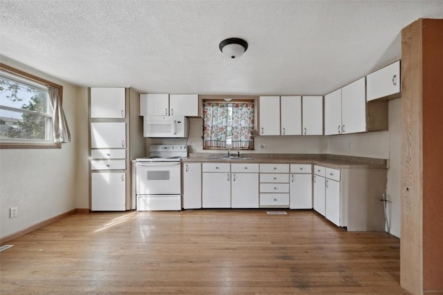 kitchen featuring white cabinetry, light hardwood / wood-style flooring, and white appliances