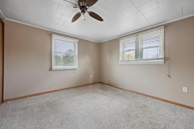 carpeted spare room featuring crown molding and ceiling fan