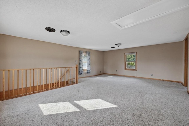 carpeted empty room featuring a textured ceiling