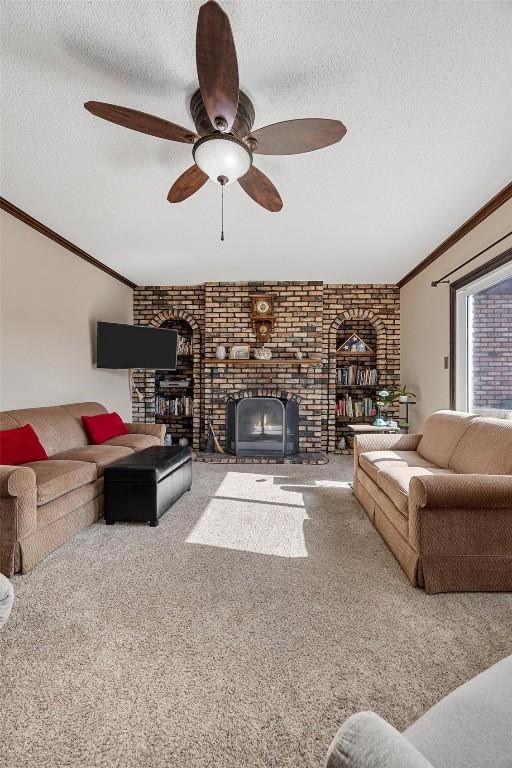 living room with a fireplace, a textured ceiling, ceiling fan, and carpet flooring