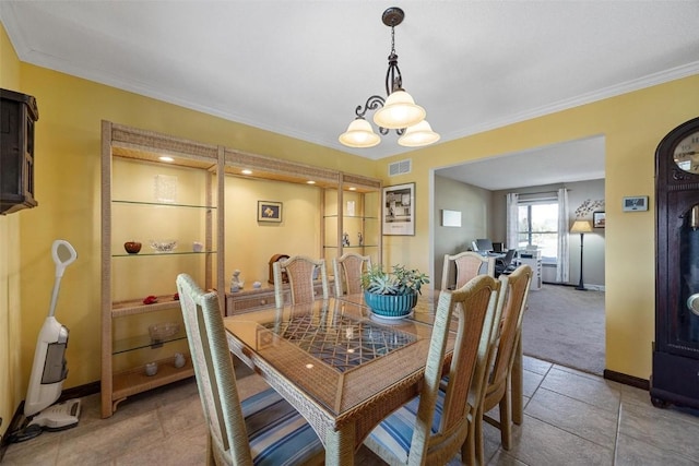 dining area with an inviting chandelier, tile patterned floors, and crown molding