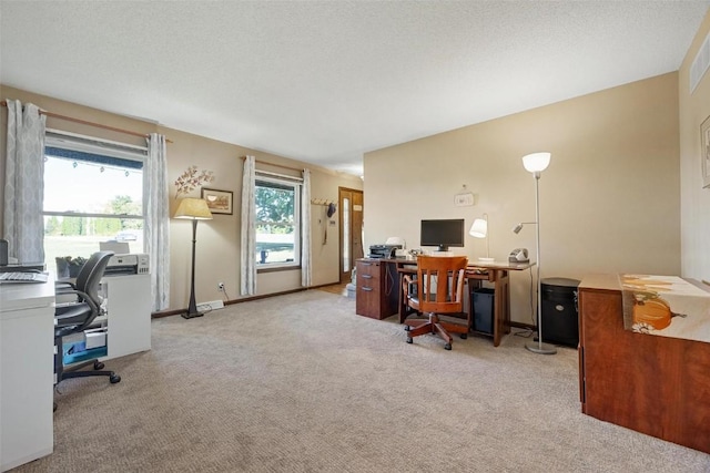 carpeted office space with a healthy amount of sunlight and a textured ceiling