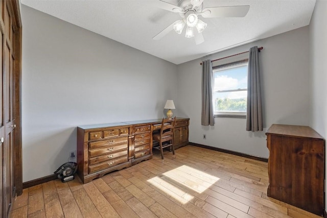 home office with ceiling fan, light hardwood / wood-style flooring, and built in desk