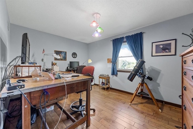 office with wood-type flooring and a textured ceiling