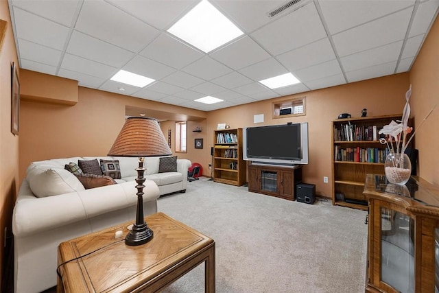 living room featuring light carpet and a drop ceiling