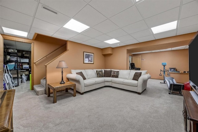 carpeted living room with a drop ceiling