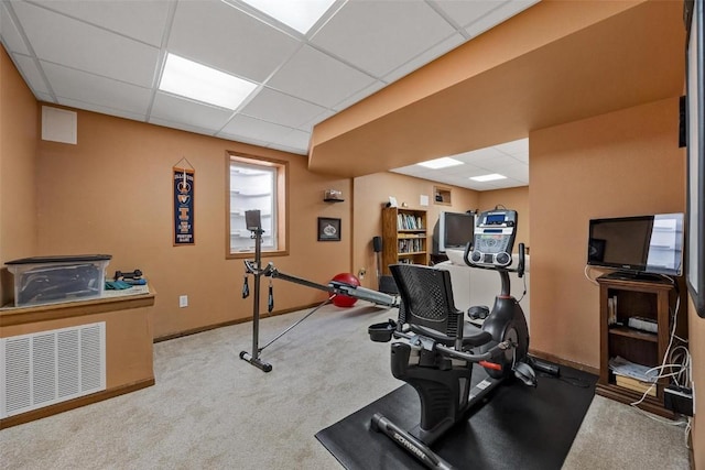 workout room with light colored carpet and a drop ceiling