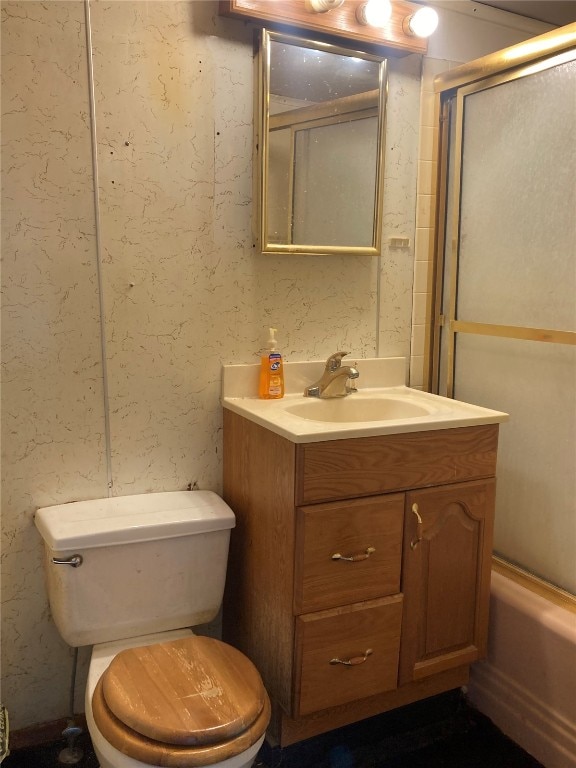 full bathroom featuring enclosed tub / shower combo, vanity, and toilet