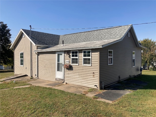 rear view of property featuring a lawn