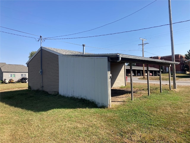 view of outbuilding with a lawn and a carport