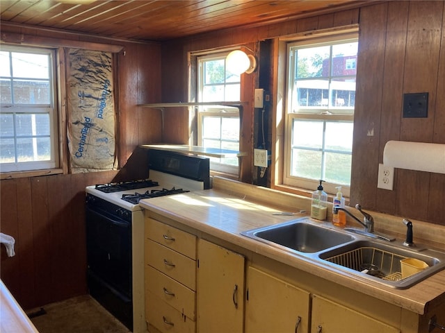 kitchen with sink, a wealth of natural light, white gas stove, and wooden ceiling