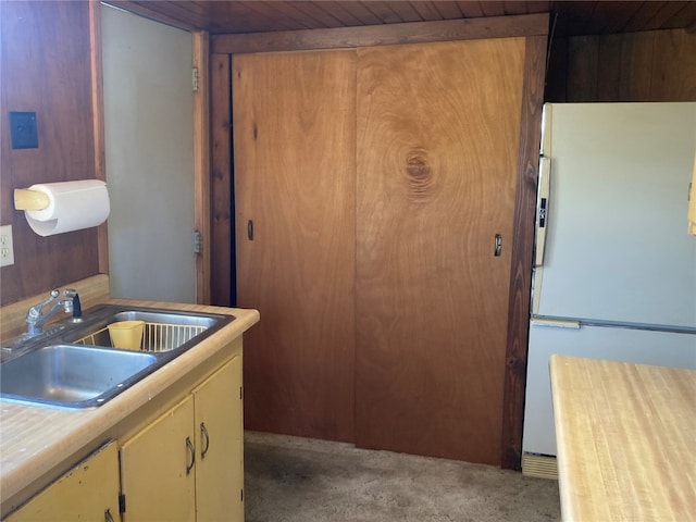 kitchen with sink, white fridge, carpet, and wooden ceiling