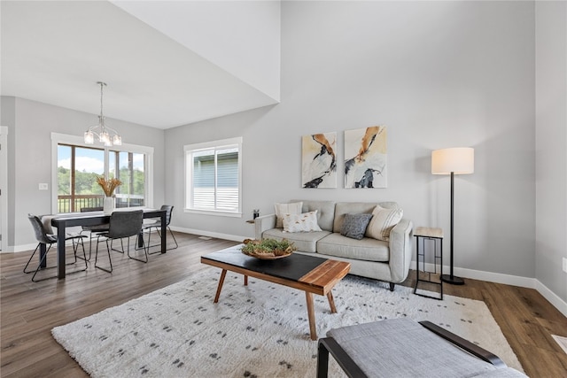 living room with a notable chandelier and dark hardwood / wood-style flooring