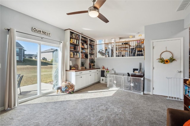 interior space with carpet floors and ceiling fan