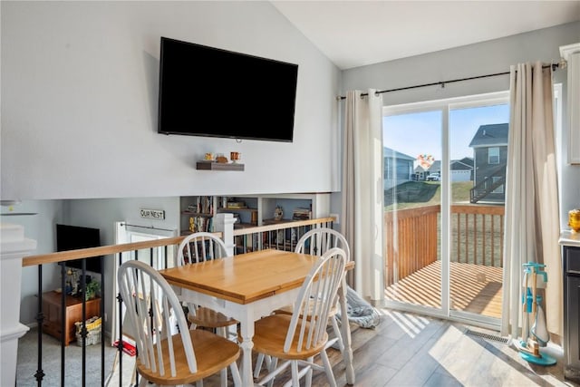 dining space with lofted ceiling and hardwood / wood-style floors