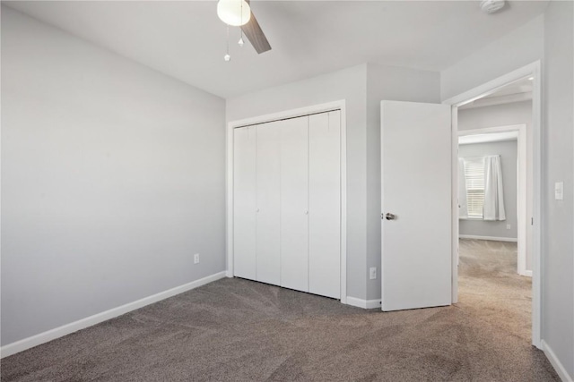 unfurnished bedroom featuring ceiling fan, a closet, and carpet