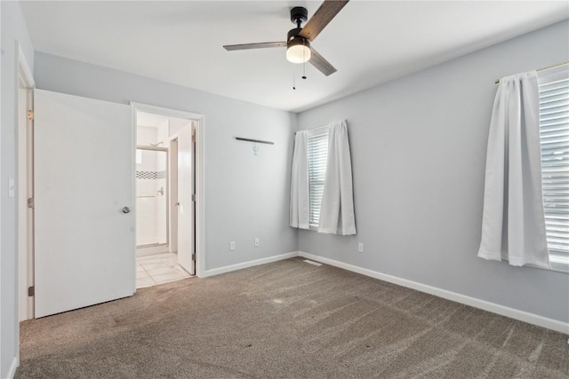 unfurnished bedroom with connected bathroom, light colored carpet, and ceiling fan