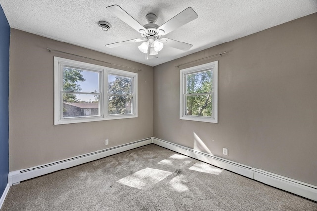 carpeted spare room with ceiling fan, a textured ceiling, and a wealth of natural light