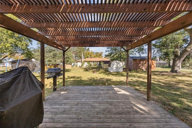 deck featuring grilling area, a pergola, a storage shed, and a lawn