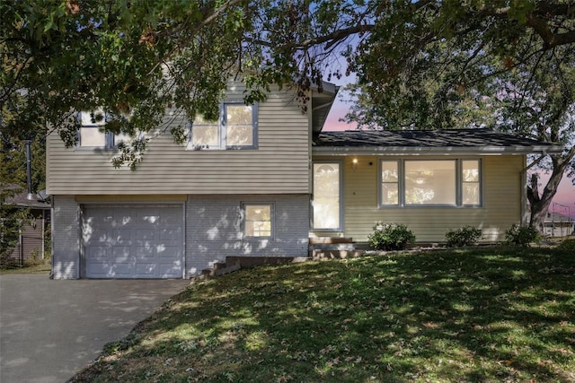 tri-level home featuring a lawn and a garage