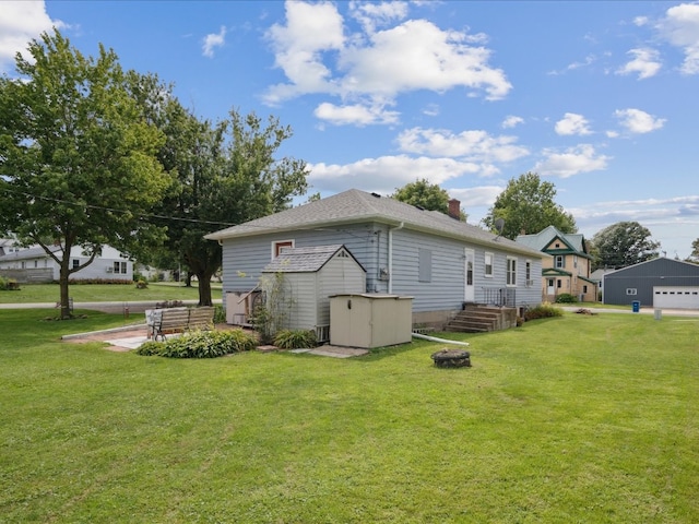 view of side of home with a lawn and a storage unit