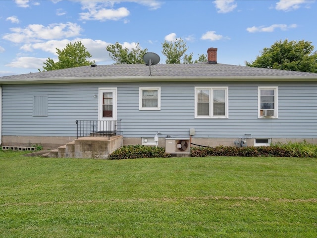 rear view of house featuring a yard and ac unit