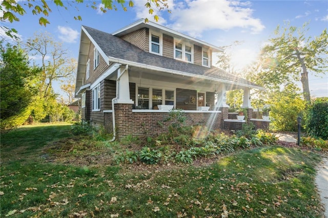 view of front of property featuring covered porch and a front lawn