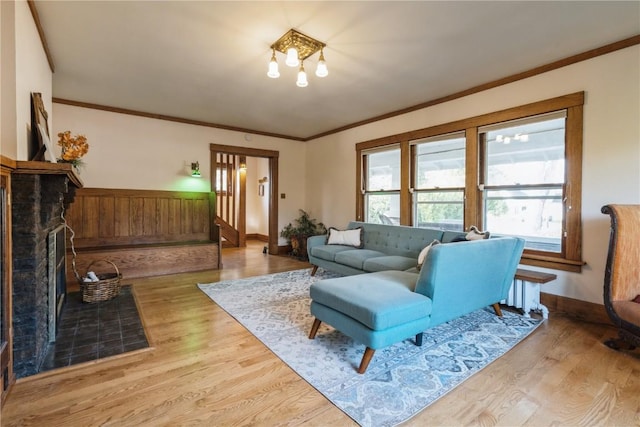 living room with light hardwood / wood-style floors, crown molding, and an inviting chandelier