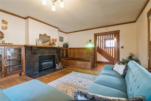 living room featuring light hardwood / wood-style floors, ornamental molding, and a fireplace