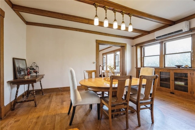 dining room featuring a wall unit AC, beamed ceiling, and light wood-type flooring