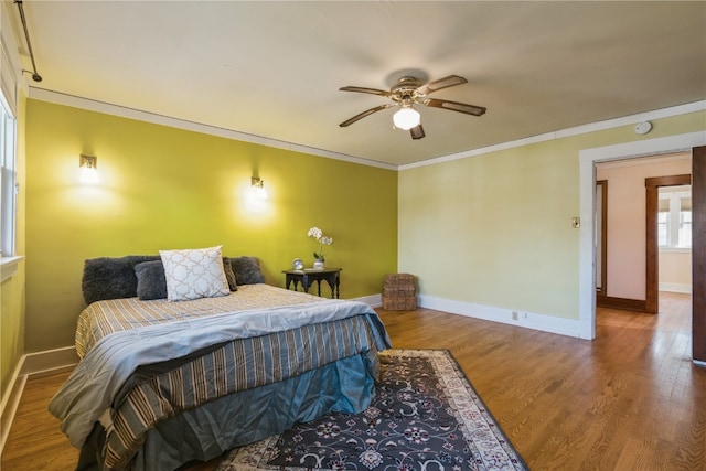 bedroom featuring hardwood / wood-style floors, ceiling fan, and ornamental molding