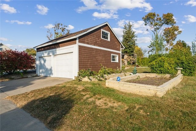 view of side of home featuring a garage, an outdoor structure, and a lawn