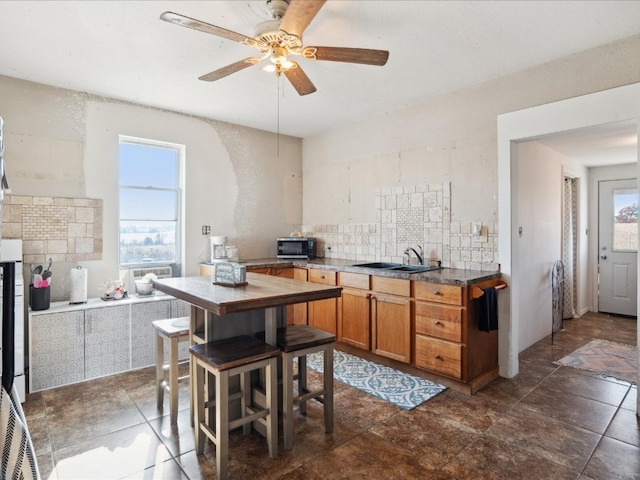 kitchen featuring sink, ceiling fan, a healthy amount of sunlight, and tasteful backsplash