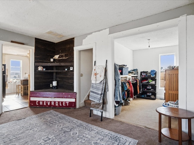 carpeted bedroom featuring wood walls and a textured ceiling