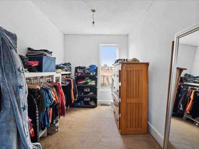 walk in closet featuring light colored carpet