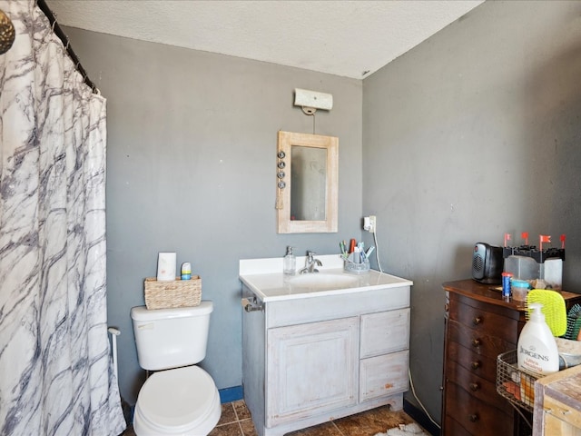 bathroom with vanity, toilet, tile patterned floors, and a textured ceiling