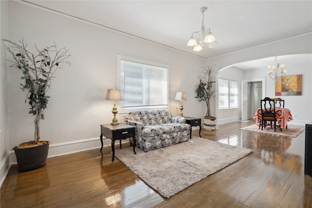 interior space with an inviting chandelier, crown molding, and dark hardwood / wood-style flooring