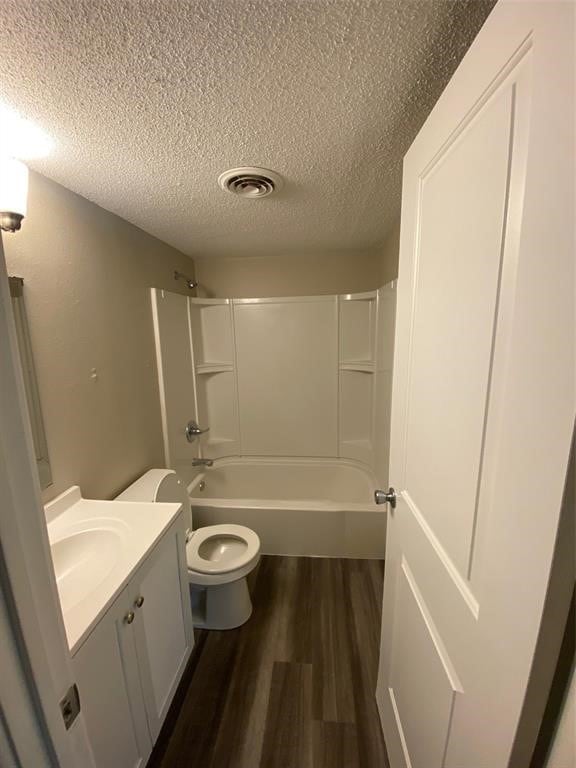 full bathroom with hardwood / wood-style floors, toilet, shower / tub combination, and vanity