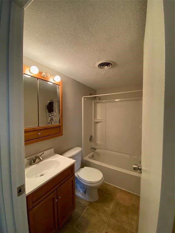 full bathroom with bathing tub / shower combination, a textured ceiling, vanity, and toilet