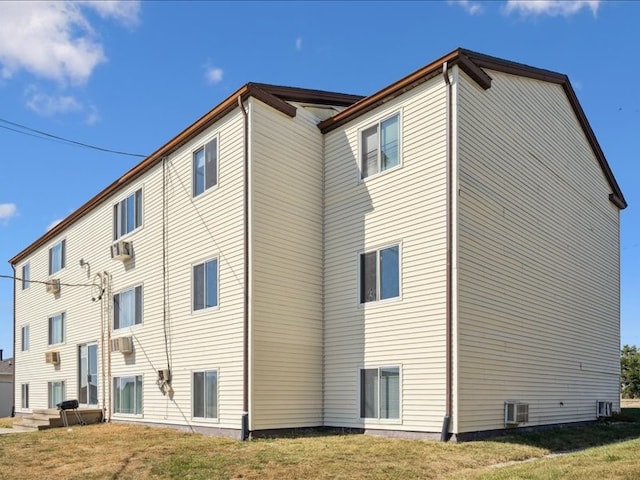 back of property featuring central AC unit, cooling unit, and a yard