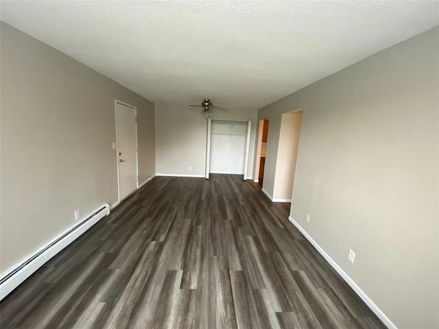 spare room with a textured ceiling, ceiling fan, a baseboard heating unit, and dark hardwood / wood-style flooring