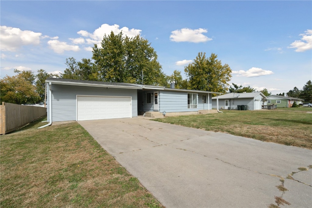 ranch-style house featuring a front lawn and a garage