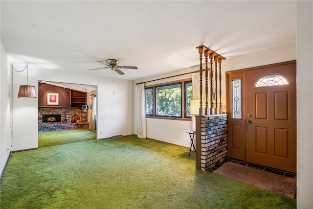 carpeted entryway featuring ceiling fan, a fireplace, and a wealth of natural light